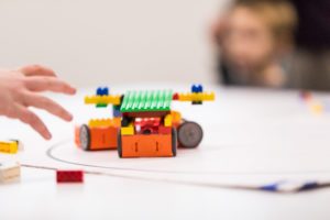 kid reaching for a lego robot